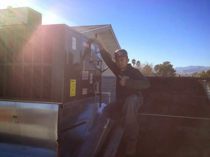 HVAC technician performing HVAC Inspection on a rooftop unit in Salina